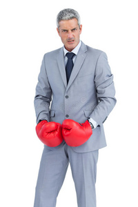 愤怒的商人戴着拳击手套摆姿势