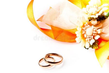 金色结婚戒指，靠近丝带和鲜花，有文字空间