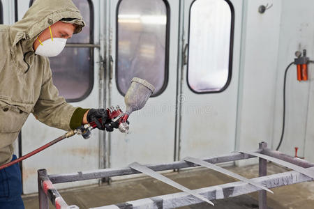 穿防护服,戴口罩的人给汽车喷漆照片