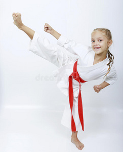 一个穿白色和服，系着红腰带的女孩在踢腿