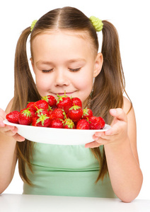 快乐的小女孩在闻草莓