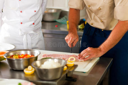 厨师在餐厅或酒店厨房准备鱼图片