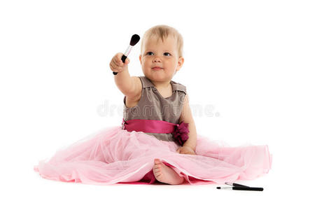 可爱的小女孩穿着粉红色的裙子坐在地板上