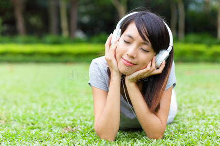 亚洲女人躺在草地上听歌曲图片