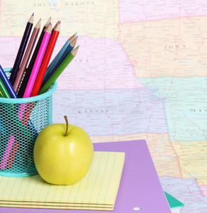 回到学校的概念。地图上一堆书上的苹果和彩色铅笔