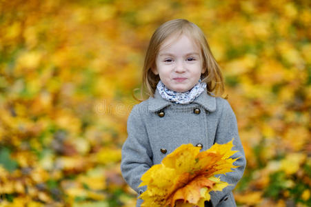 可爱的女孩在秋日玩得开心
