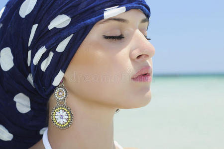 海滩上披着蓝色披肩的美女肖像。阿拉伯风格