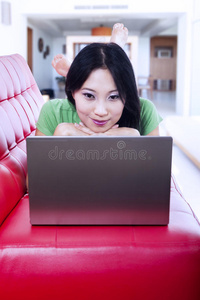 红色沙发上美女在家上网