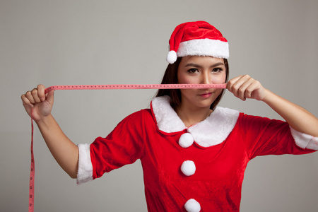 亚洲圣诞圣诞老人衣服饮食与测量中的女孩