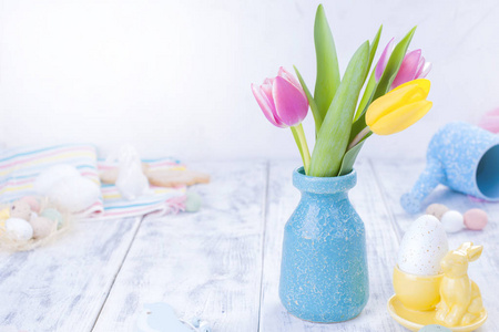 一小束粉红色的郁金香在一个蓝色的花瓶。复活节装饰。文本复制空间的可用空间