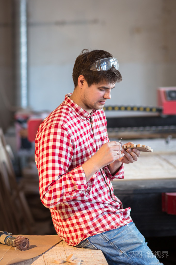 熟练的木匠师傅手磨砂纸木质件的木 t