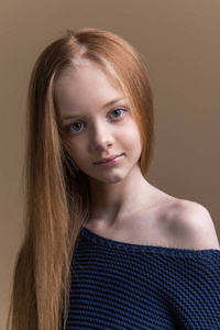 米色背景下的摄影棚中美丽的年轻红发的特写肖像