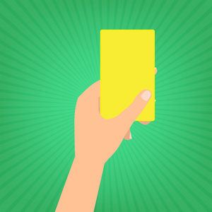 人类的手拿着一张黄色的卡片在绿色的太阳射线背景上。