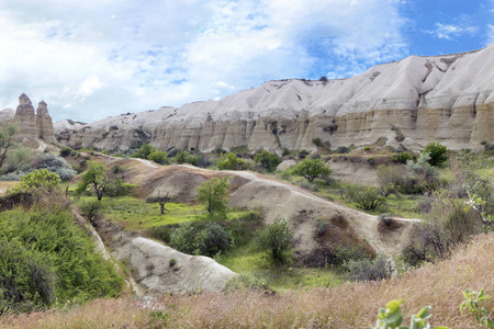 红色和白色砂岩峭壁, 古洞穴在山风景之间的山谷之间, 中部土耳其