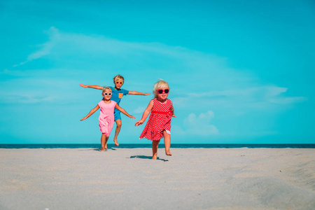 快乐的孩子男孩和女孩跑在海滩上玩耍