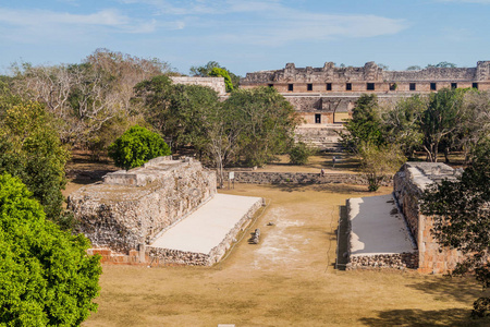 球场 胡埃戈de Pelota 和尼姑的四合院 Cuadrangulo de Monjas 在背景在古玛雅城市的废墟乌