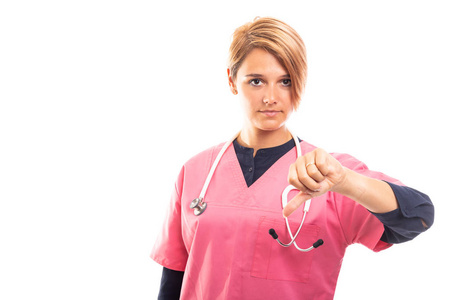身着粉红色擦洗的女兽医肖像显示拇指向下手势在白色背景下与 copyspace 广告区隔离