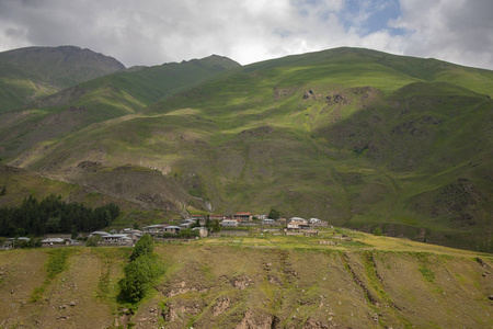 一座美丽的山景, 俯瞰着绿草蓝天点缀的村庄