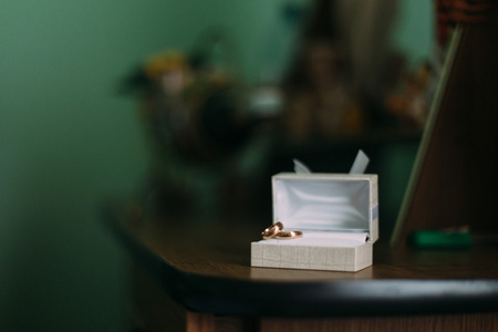 豪华时尚黄金结婚戒指在白色的盒子，木制的桌子上