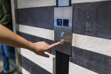 按下电梯按钮的女人图片