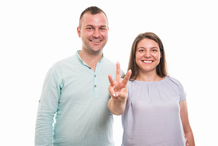年轻幸福夫妇的肖像显示数字三与手指在白色背景下与 copyspace 广告区隔离