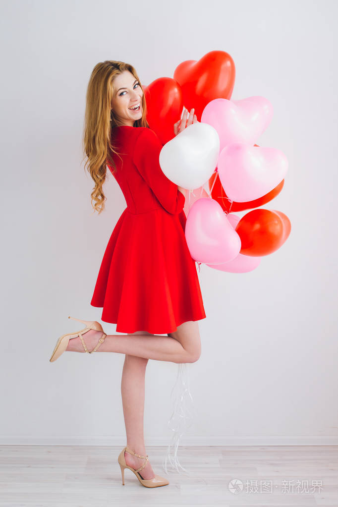 女孩穿着红色气球中的一颗心的形状