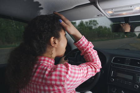 紧张的女司机坐在车轮, 有担心的表情作为 afraids 自己开车第一次.