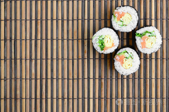 寿司卷位于竹秸秆serwing 垫上 传统的亚洲食品 顶部视图 平面平躺极简拍摄与复制空间照片 正版商用图片0qokf1 摄图新视界