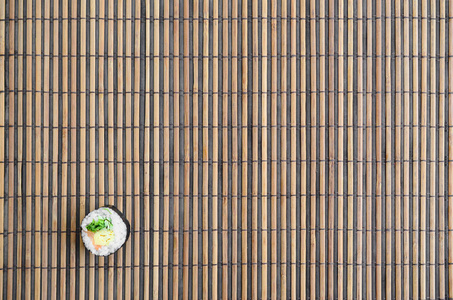 寿司卷躺在竹稻草 serwing 垫上。传统的亚洲食品。顶部视图。平面平躺极简拍摄与复制空间
