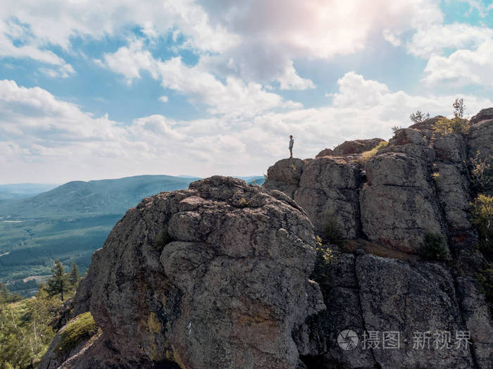 人类站在山上的悬崖上, 望向远方.令人惊叹的景色