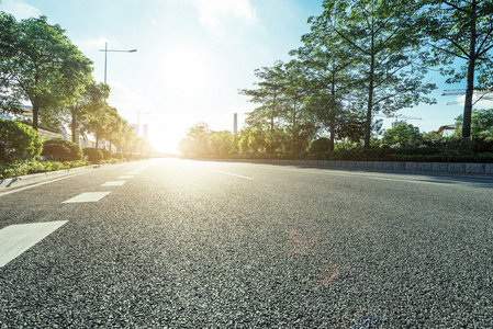 空的沥青路面在日出时的现代城市