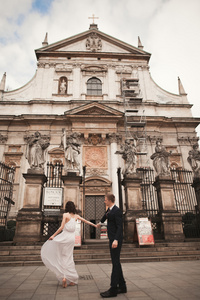 新娘和新郎背景下的美丽的教堂。漂亮的旧建筑。建筑学的婚礼