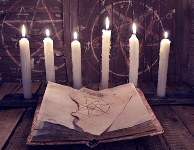 与五芒星和邪恶蜡烛为隐匿性仪式魔法书照片