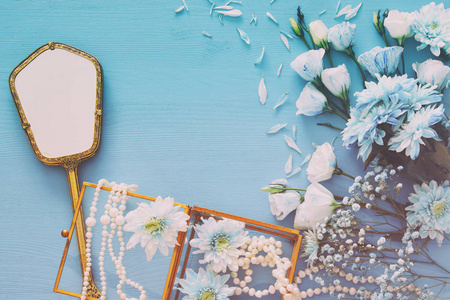 珍珠项链和手镜子旁边的美观 精致的蓝色小花安排