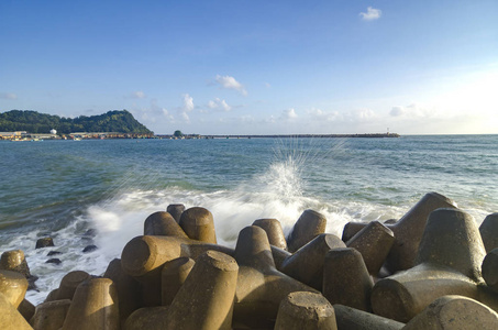 晴天上空波浪破碎混凝土防波堤的模糊选择性聚焦图像在蓝天背景下