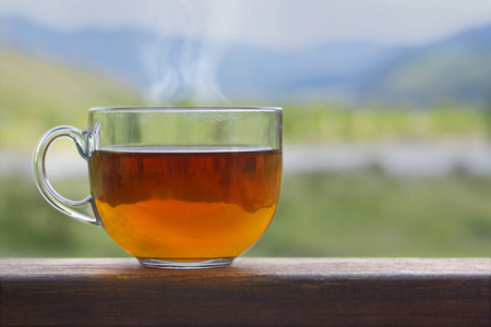 自然背景下木桌上的透明杯红茶