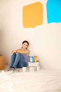 女人从新回家坐在木地板上色板选择油漆颜色