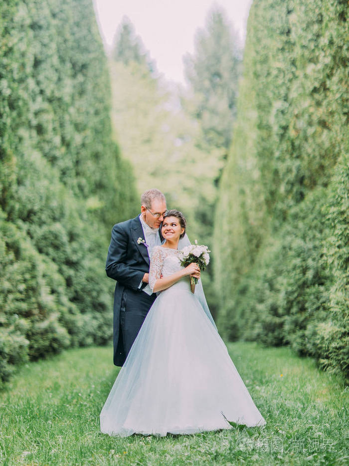 欢快的新婚夫妇拥抱在 garnde 盛开的浪漫照片