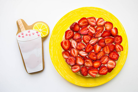 一个明亮和美味的草莓蛋糕站在桌子上与饼干的形式鸡尾酒