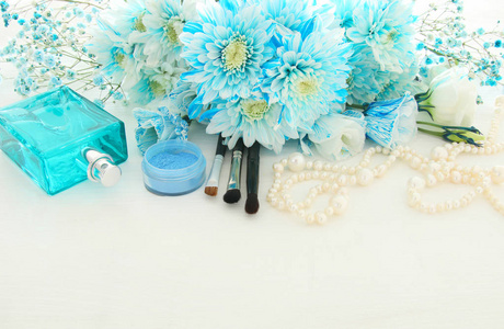 美观 精致的蓝色插花旁边的珍珠项链，清新的香水和化妆品