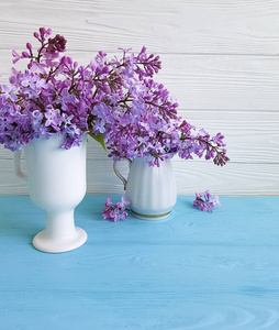 蓝色木质背景的丁香花枝, 花瓶