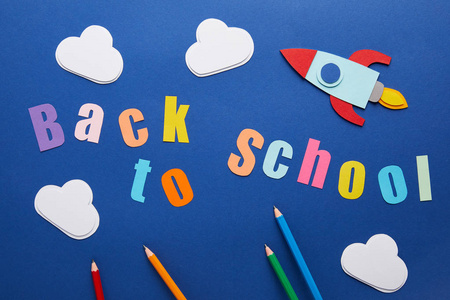 回到学校的顶部视图用铅笔云彩和火箭在蓝色背景上刻字