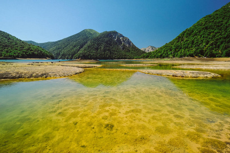 绿山蓝天下的绿色浅湖