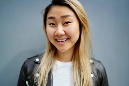 中国女郎特写在蓝色背景, 可爱开朗的亚洲女孩的年轻金发中国妇女的