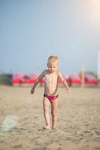 可爱的小宝贝男孩走在海边的沙滩上。海洋海岸