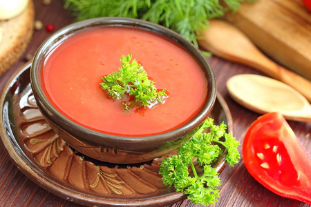 美味的西红柿汤与芳香的香料和绿色的木桌上晚餐。素食食品