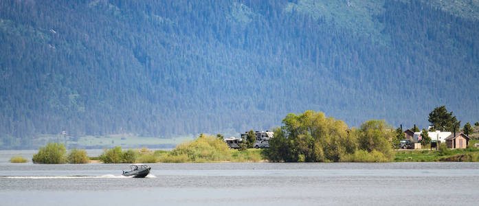 摩托艇超速穿过湖边露营地在山上