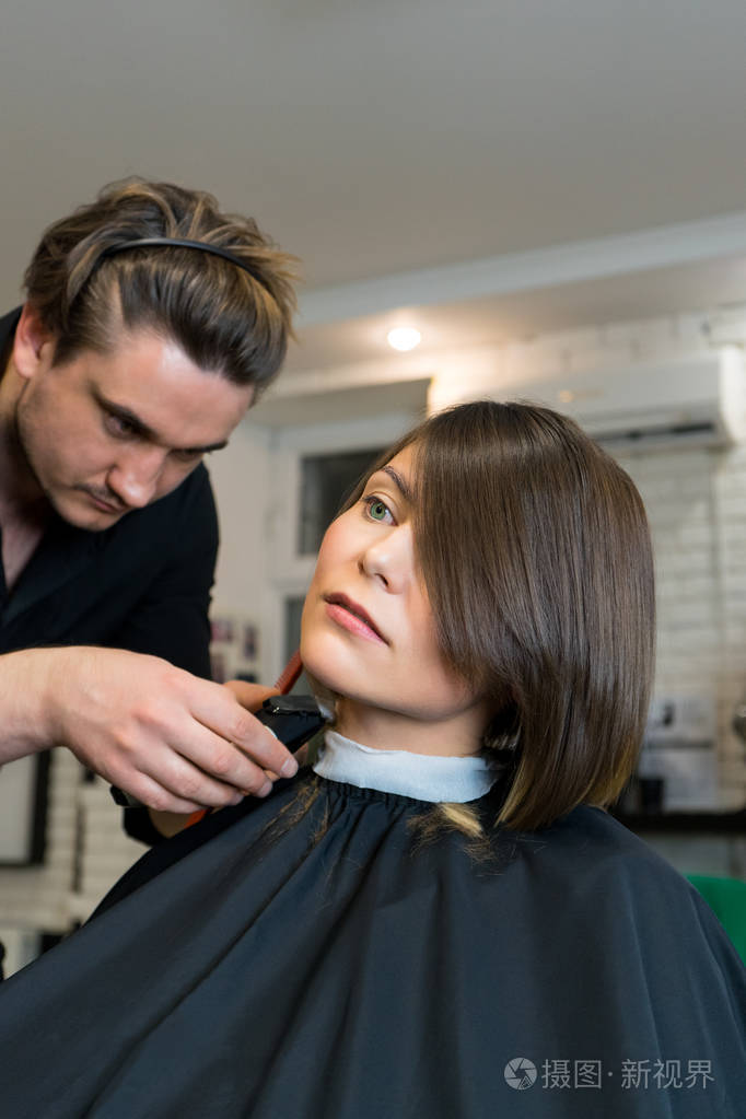 男理发师理发对漂亮的女人