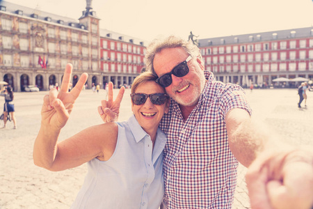 在西班牙马德里市长自拍的美丽幸福的资深夫妇。在退休旅行在欧洲附近概念