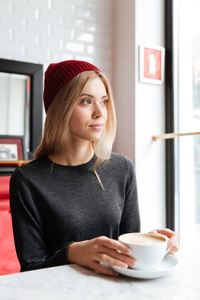 垂直图像的红色帽子与咖啡的女人